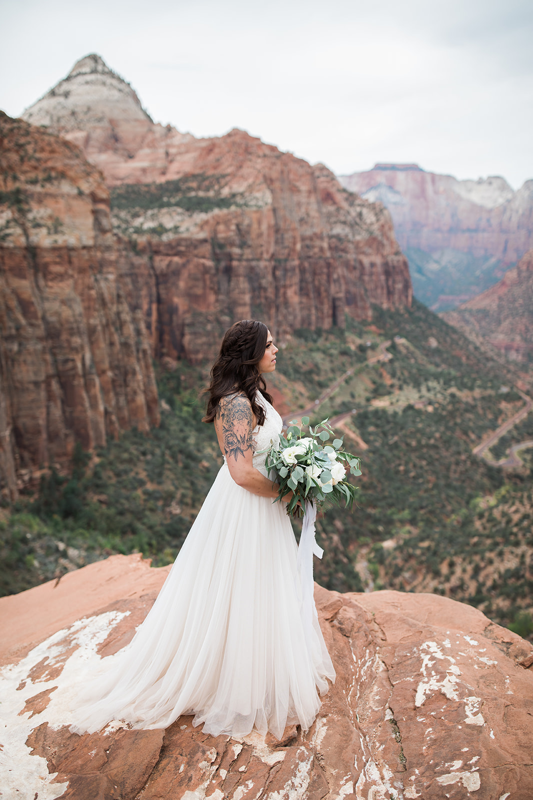 bride standing above Zion National Park mountain vista