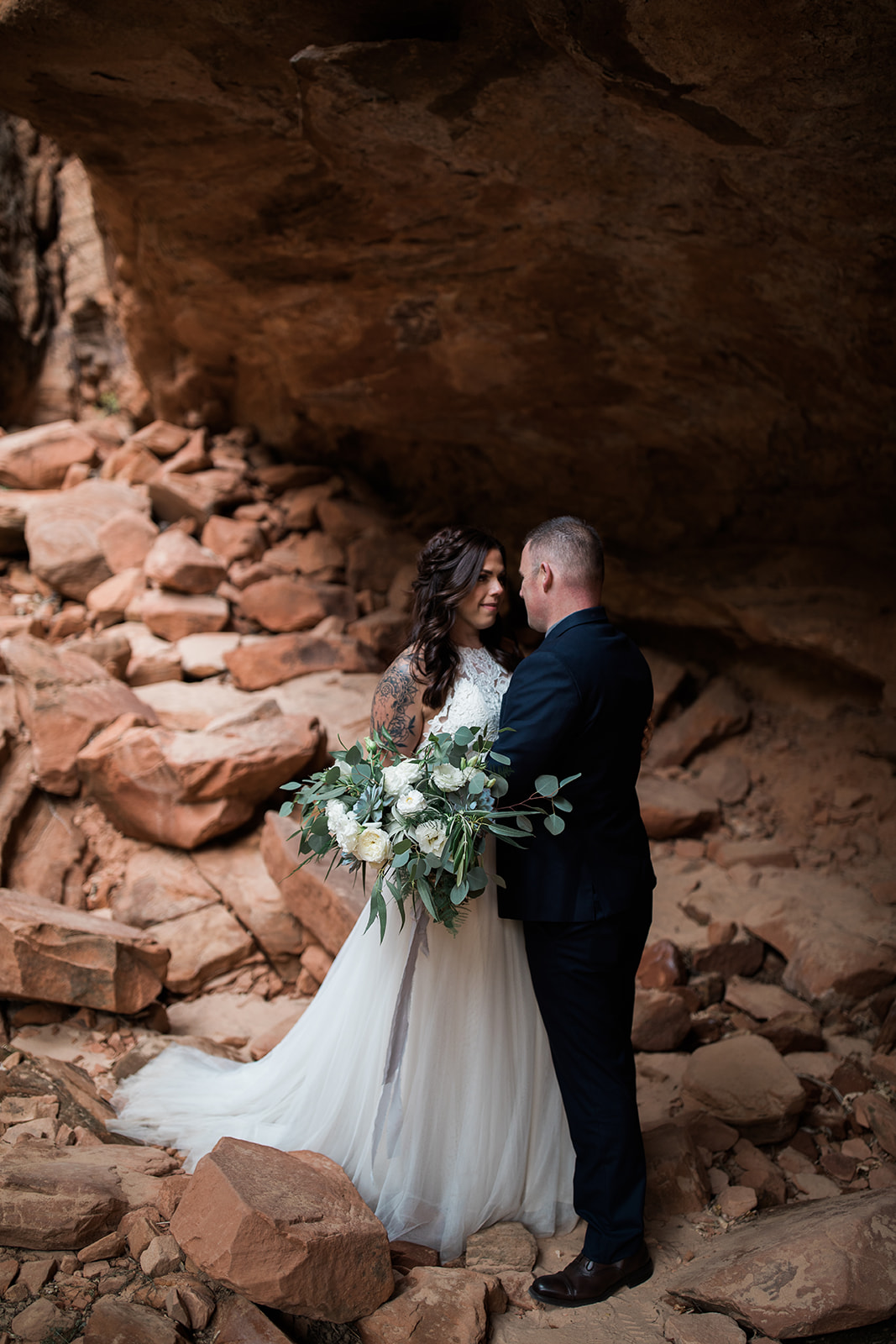 bride and groom posing in Zion rock overhang