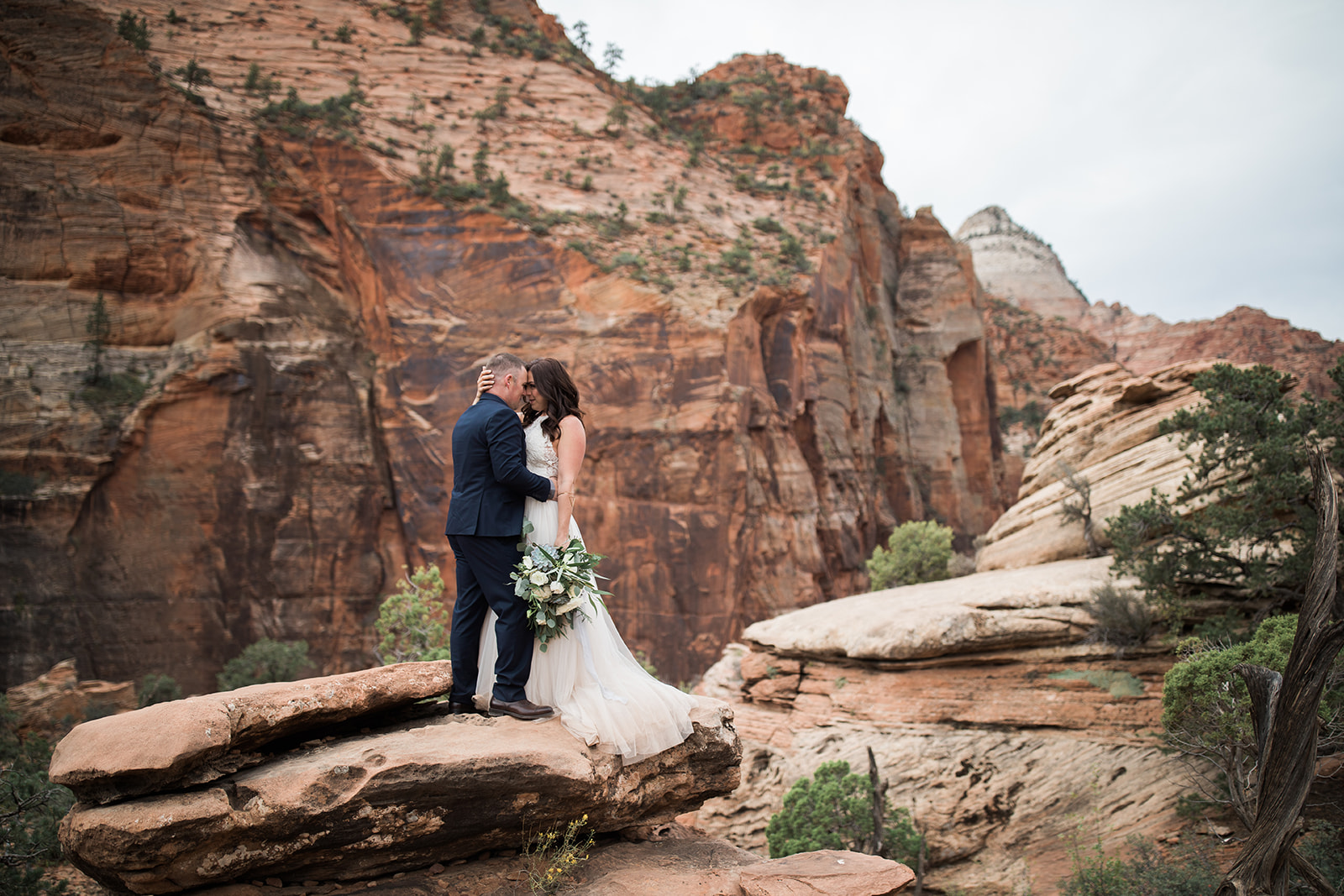 bride and groom on rock overlooking Zion panorama