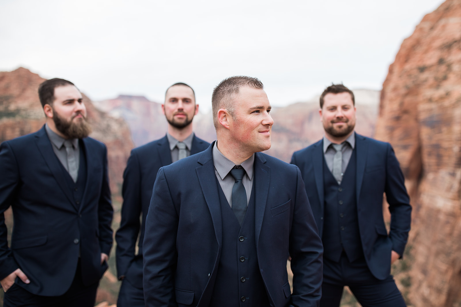 groom and groomsmen posing in front of Zion mountains