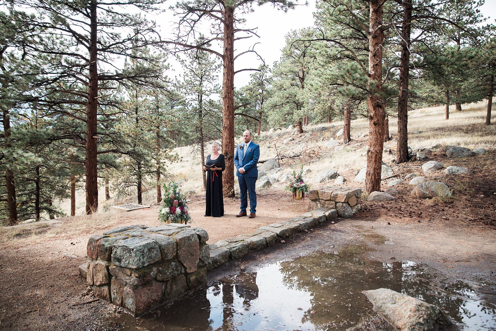 groom and officiant standing in rocky mountain national park, waiting for bride