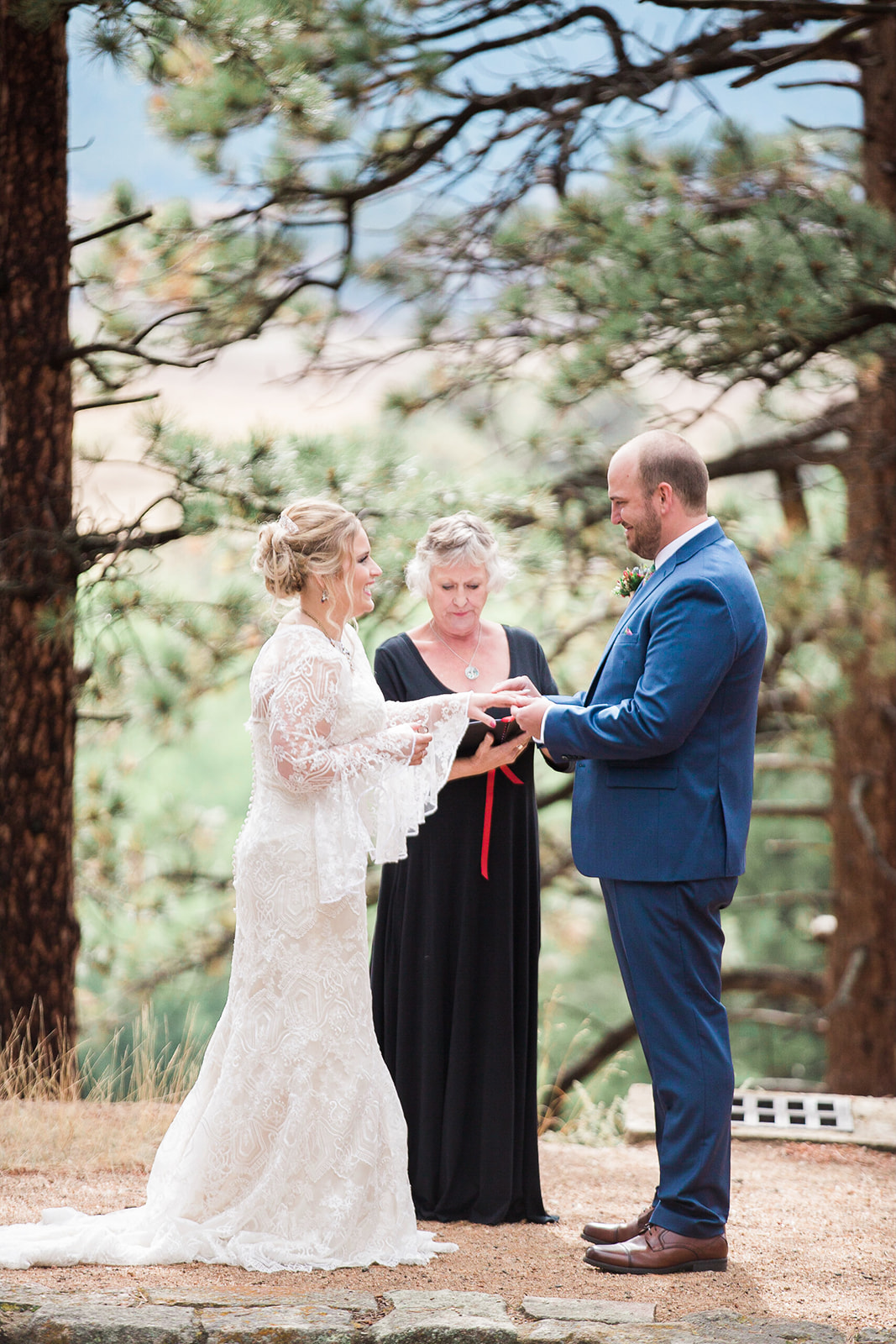 groom gives bride ring in rocky mountain national park elopement ceremony