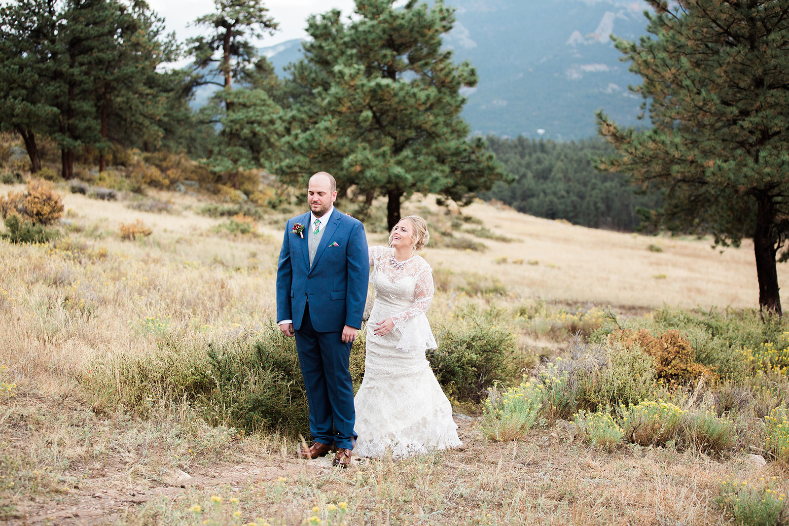 bride comes up behind groom at rocky mountain national park elopement