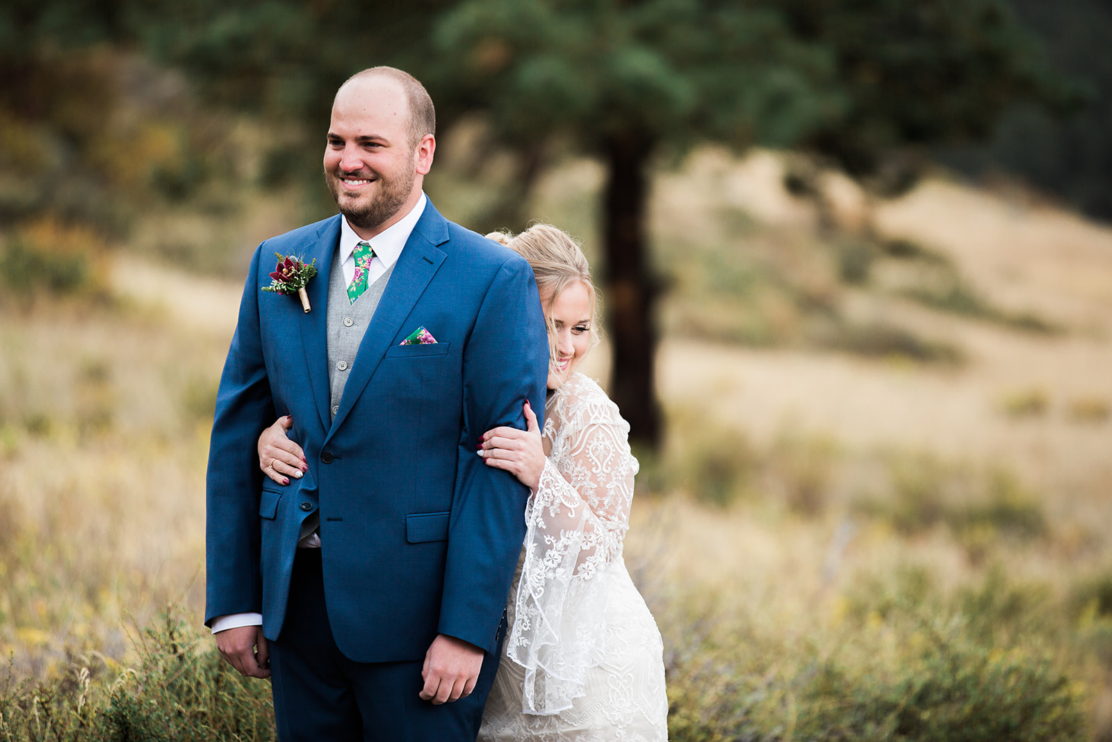 bride comes up behind groom at rocky mountain national park elopement
