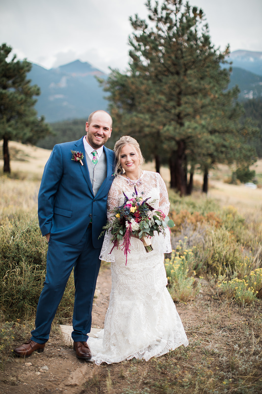 groom kisses bride in rocky mountain national park field before elopement 