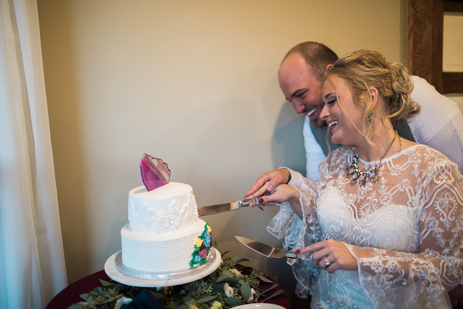 bride and groom cutting cake for colorado mountain elopement reception