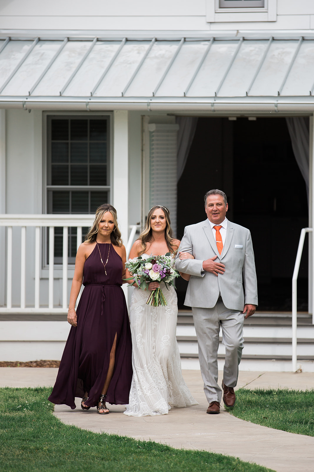 bride, father of the bride, and mother of the bride walking down the aisle