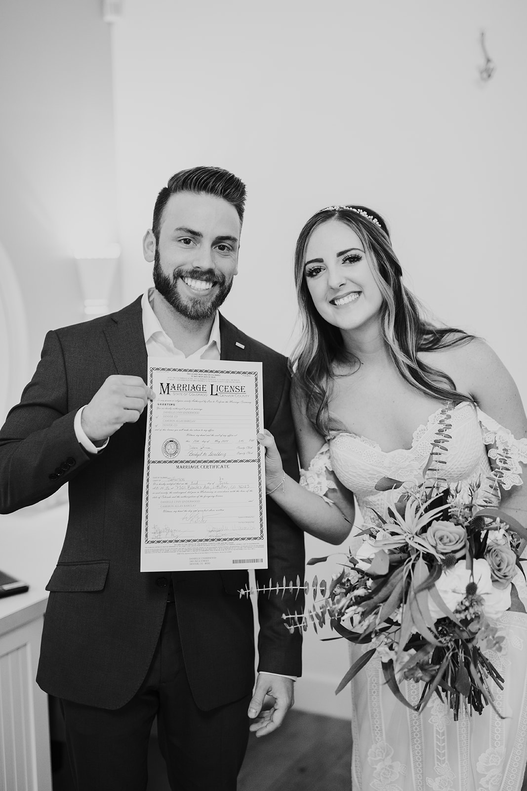 bride and groom with marriage certificate