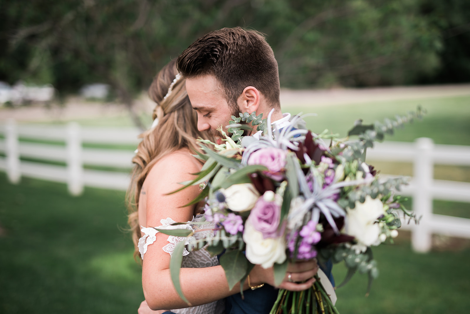 groom hugging bride with flowers
