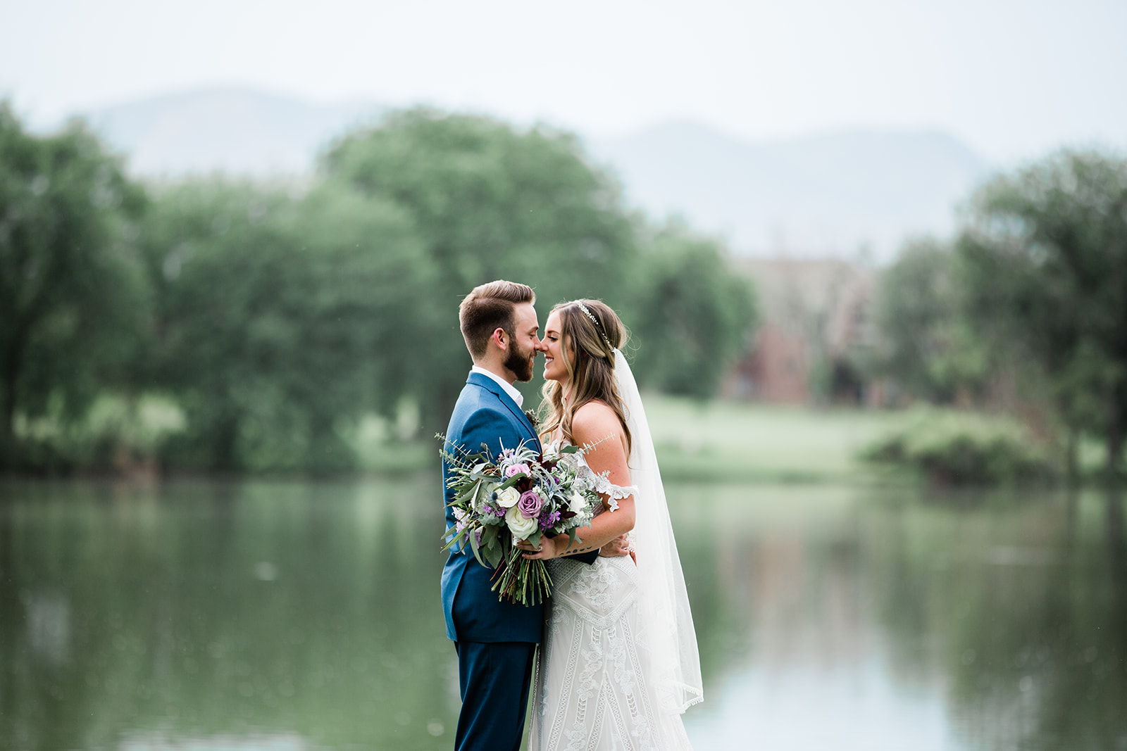 bride and groom in front of lake at Raccoon Creek