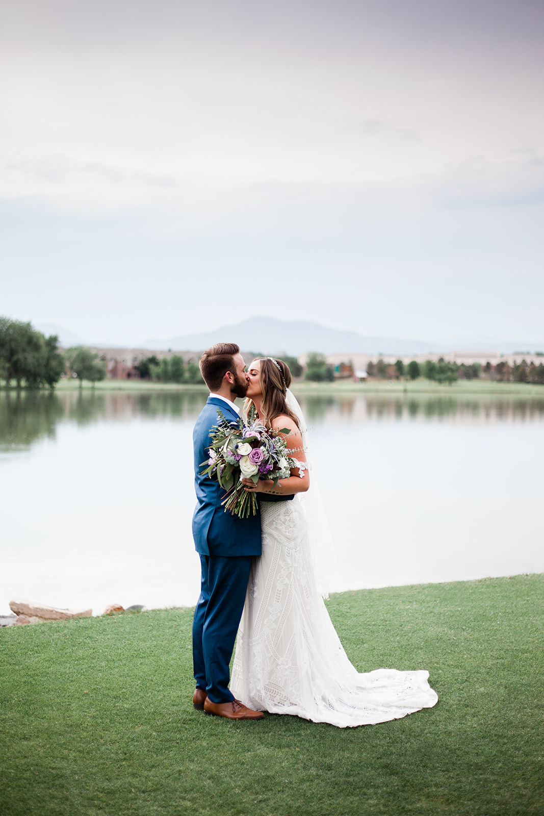 bride and groom in front of lake