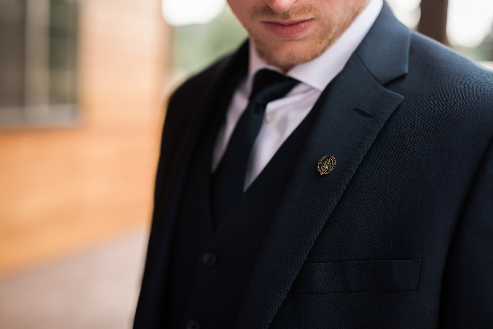 detail of groom button on suit jacket