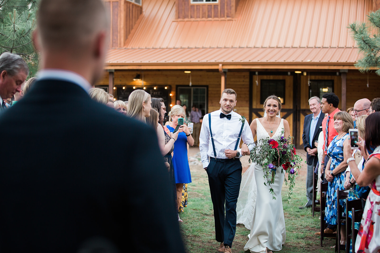 bride walks down aisle to groom at winery ceremony
