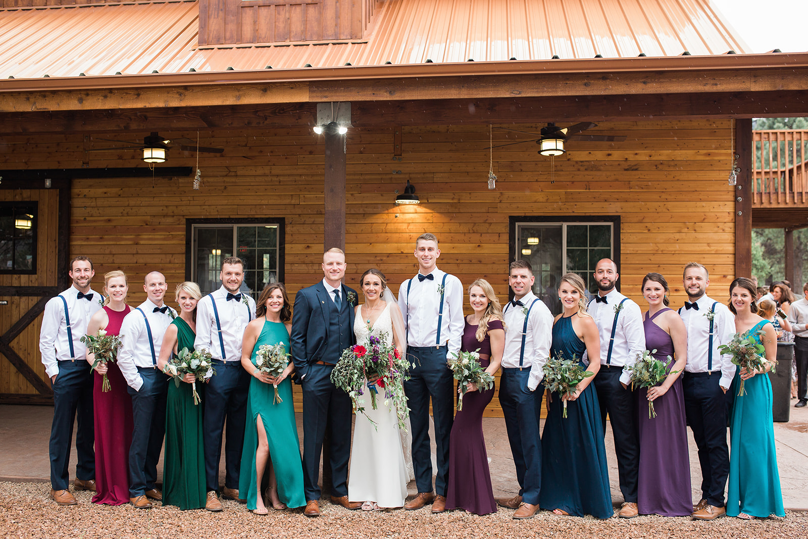 bridal party posing in front of barn
