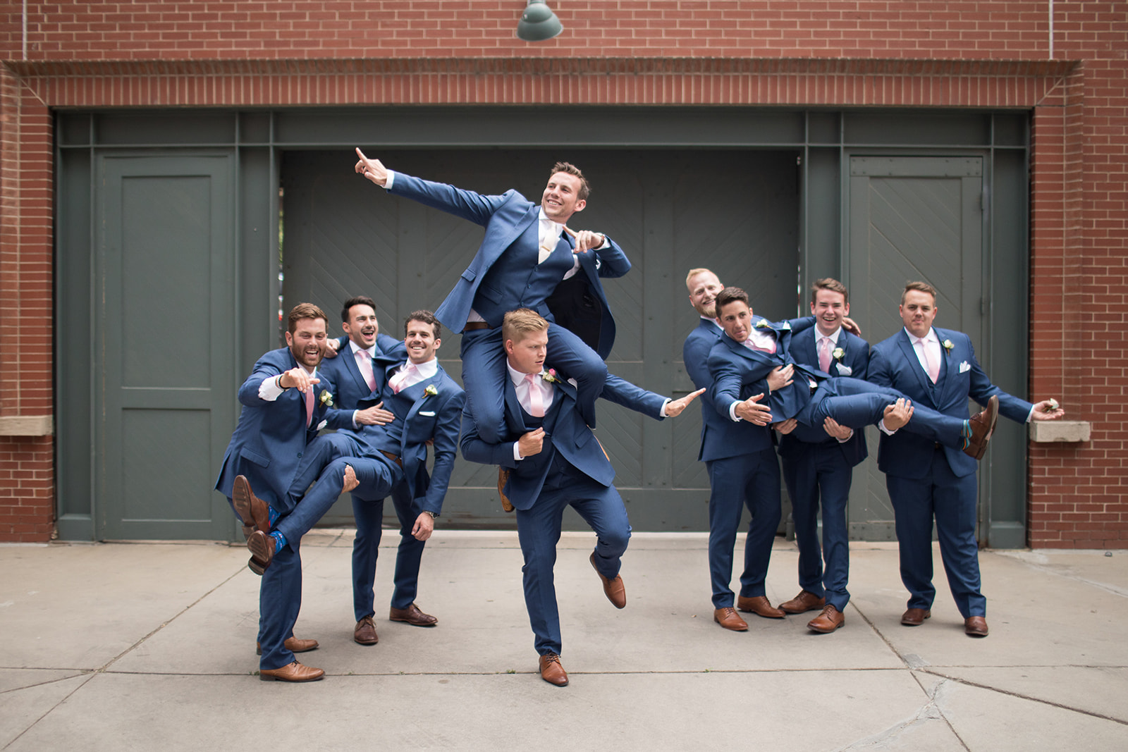 groom and groomsmen taking picture outside of space gallery downtown
