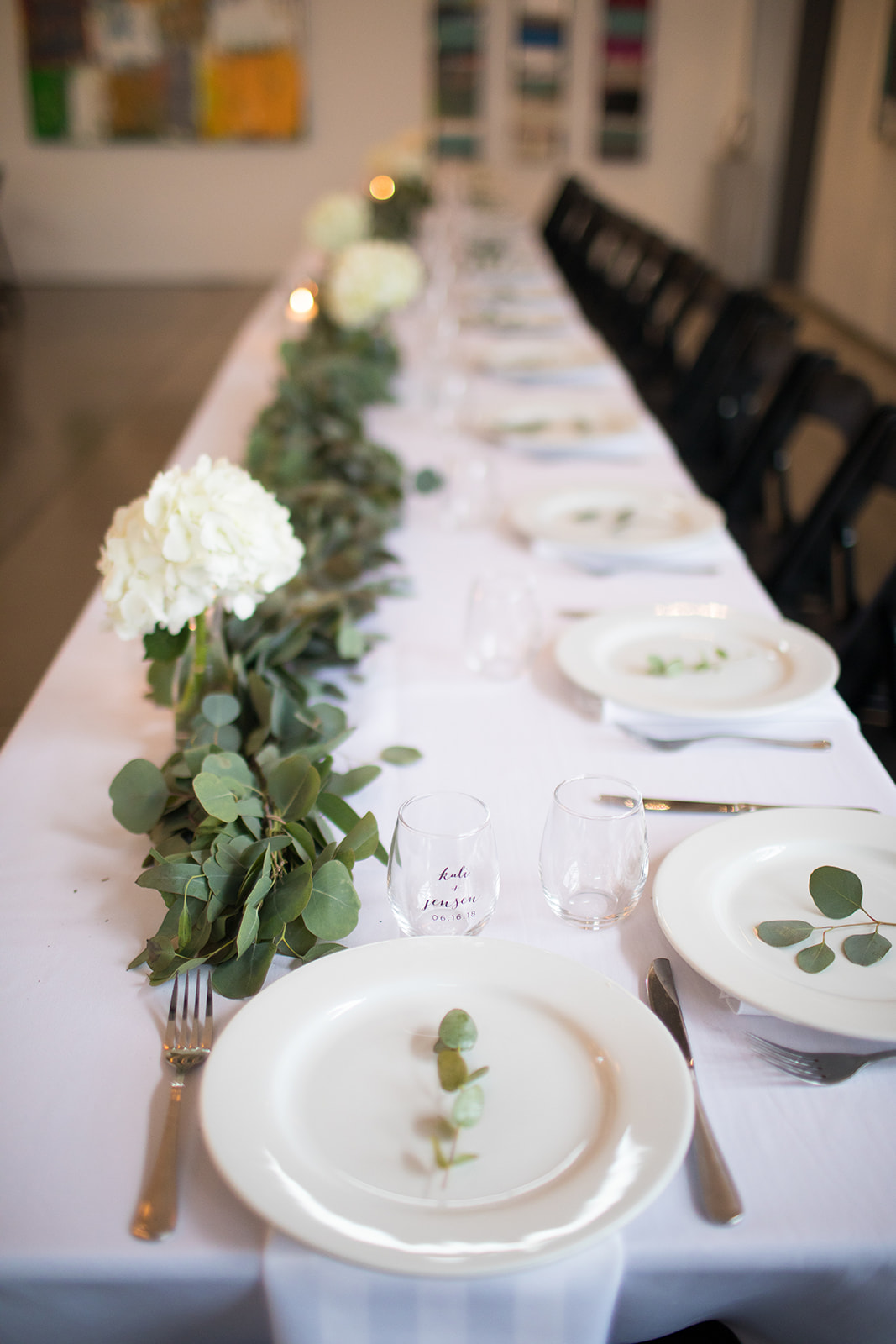 long table with garland and table settings at wedding reception
