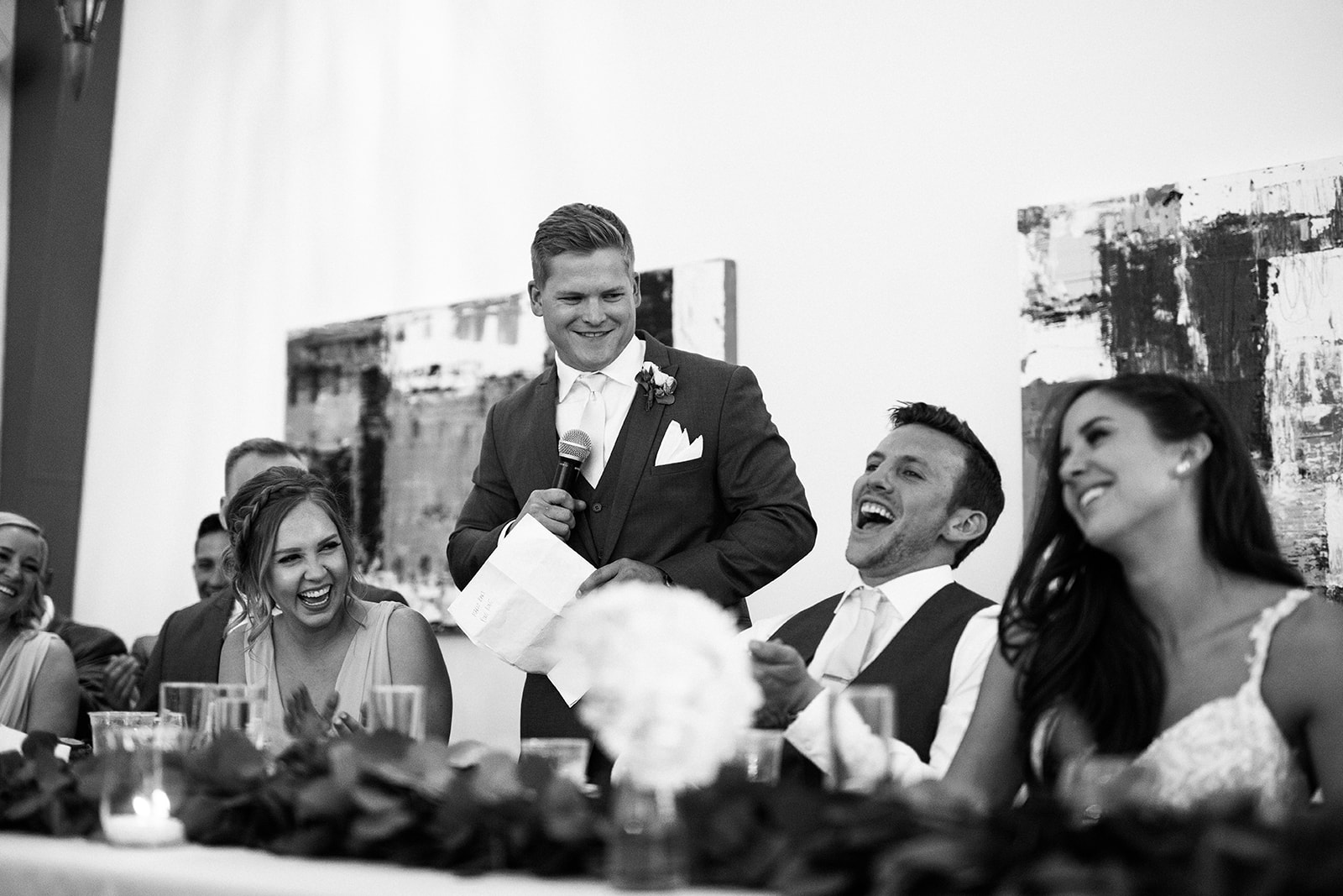 bride and groom laughing during speech at gallery wedding reception