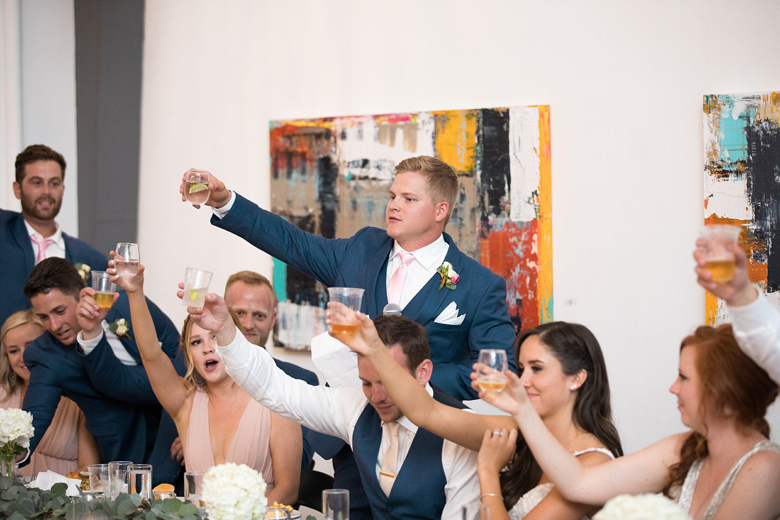 bride and groom toasting drinks at gallery wedding reception