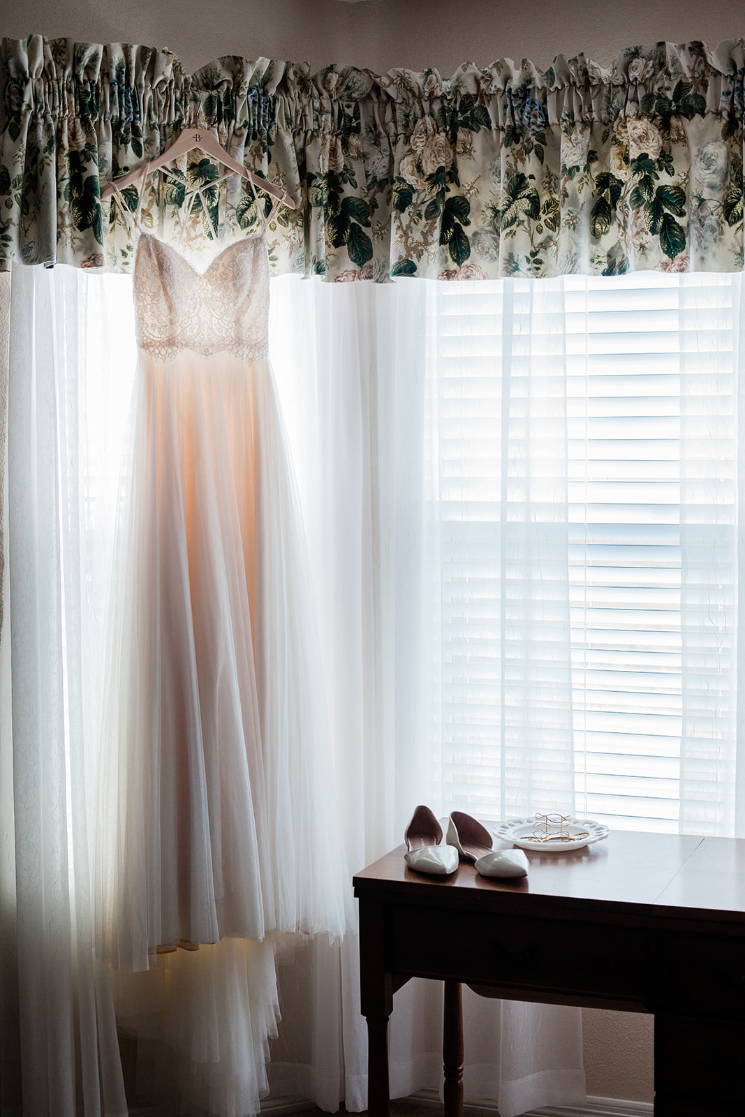 wedding dress hanging in window for intimate colorado backyard wedding