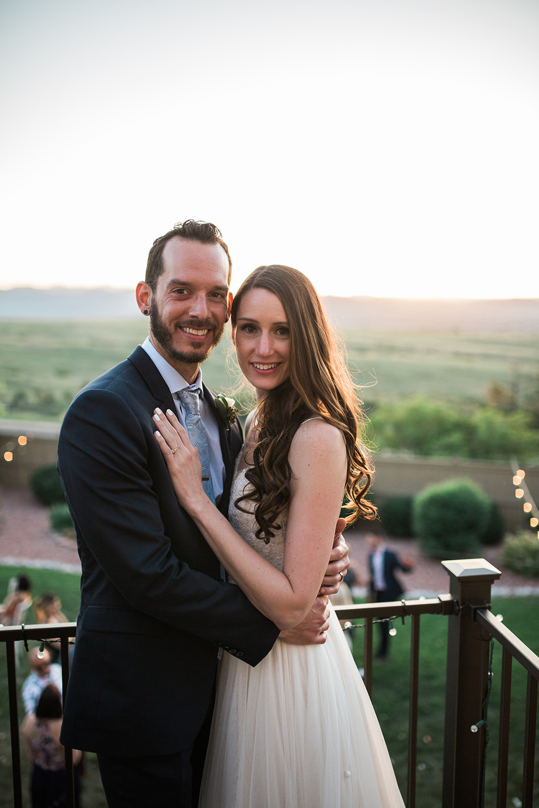 bride and groom up on balcony overlooking colorado sunset