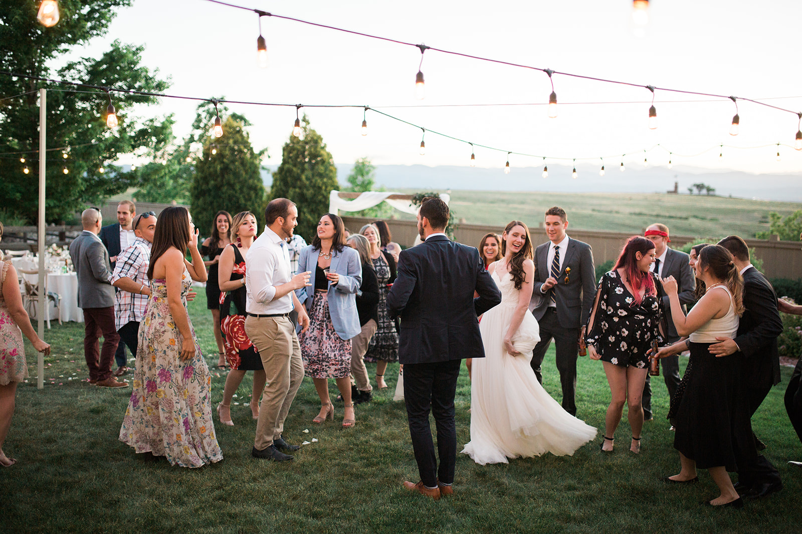 bride groom and guests dancing at intimate backyard wedding reception