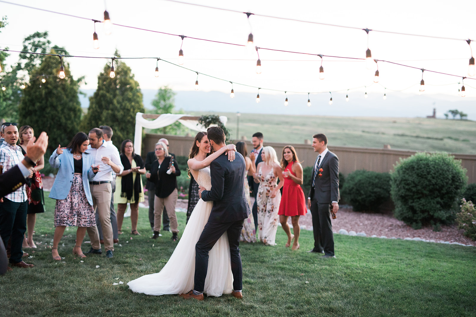 bride groom and guests dancing at intimate backyard wedding reception