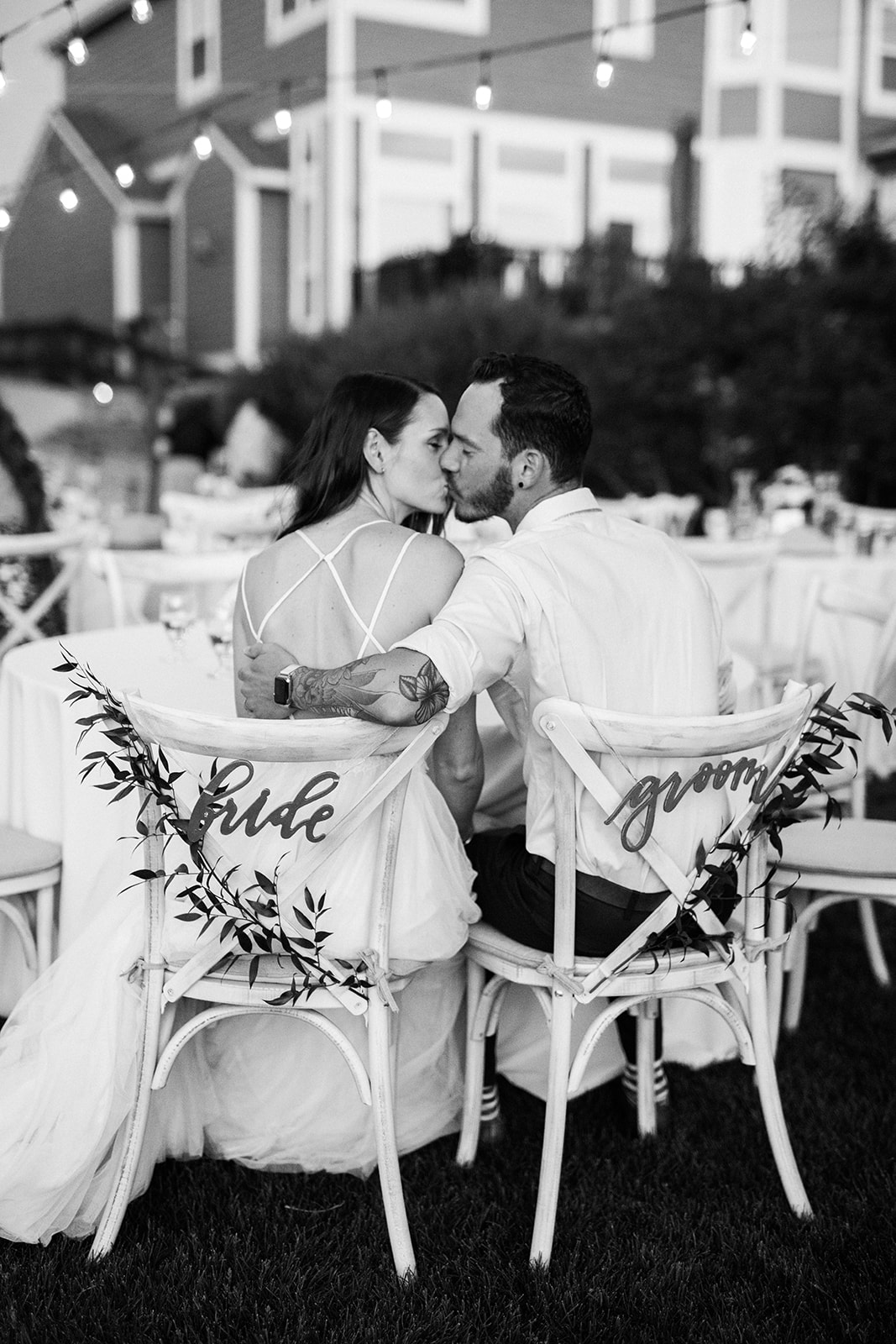 bride and groom kissing at head table during wedding reception