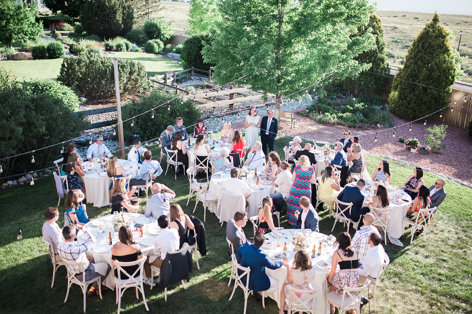 guests enjoying dinner at backyard wedding reception
