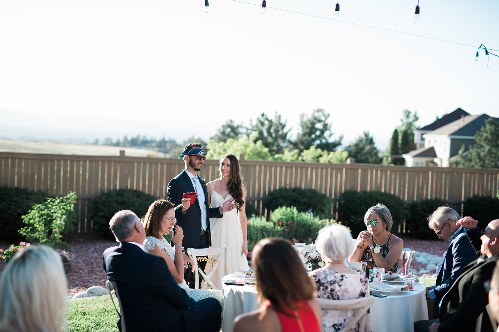 bride and groom speaking to their guests at their intimate backyard colorado wedding