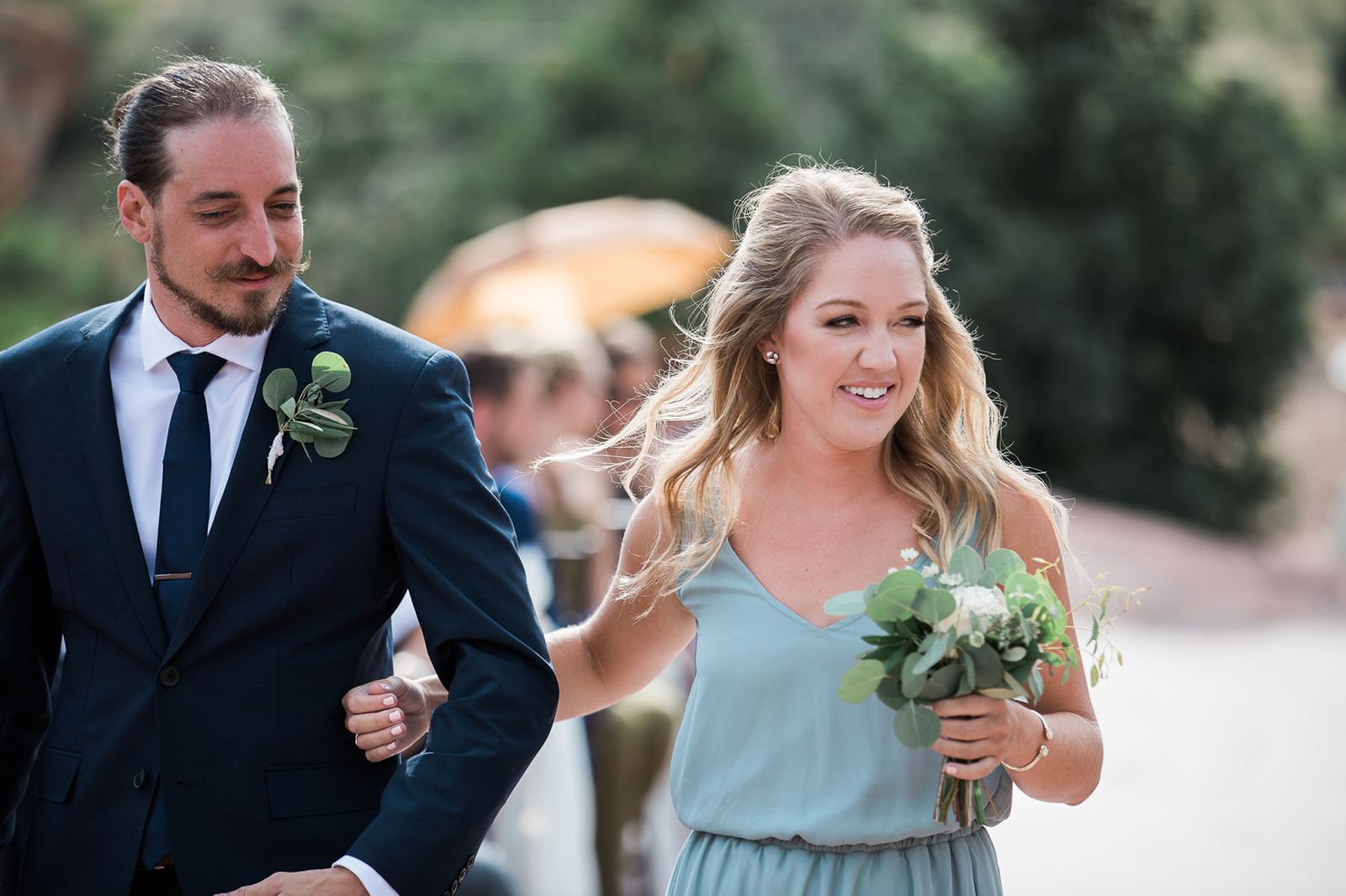 groomsman and bridesmaid walks down the aisle at Willow Ridge Manor in Morrison Colorado