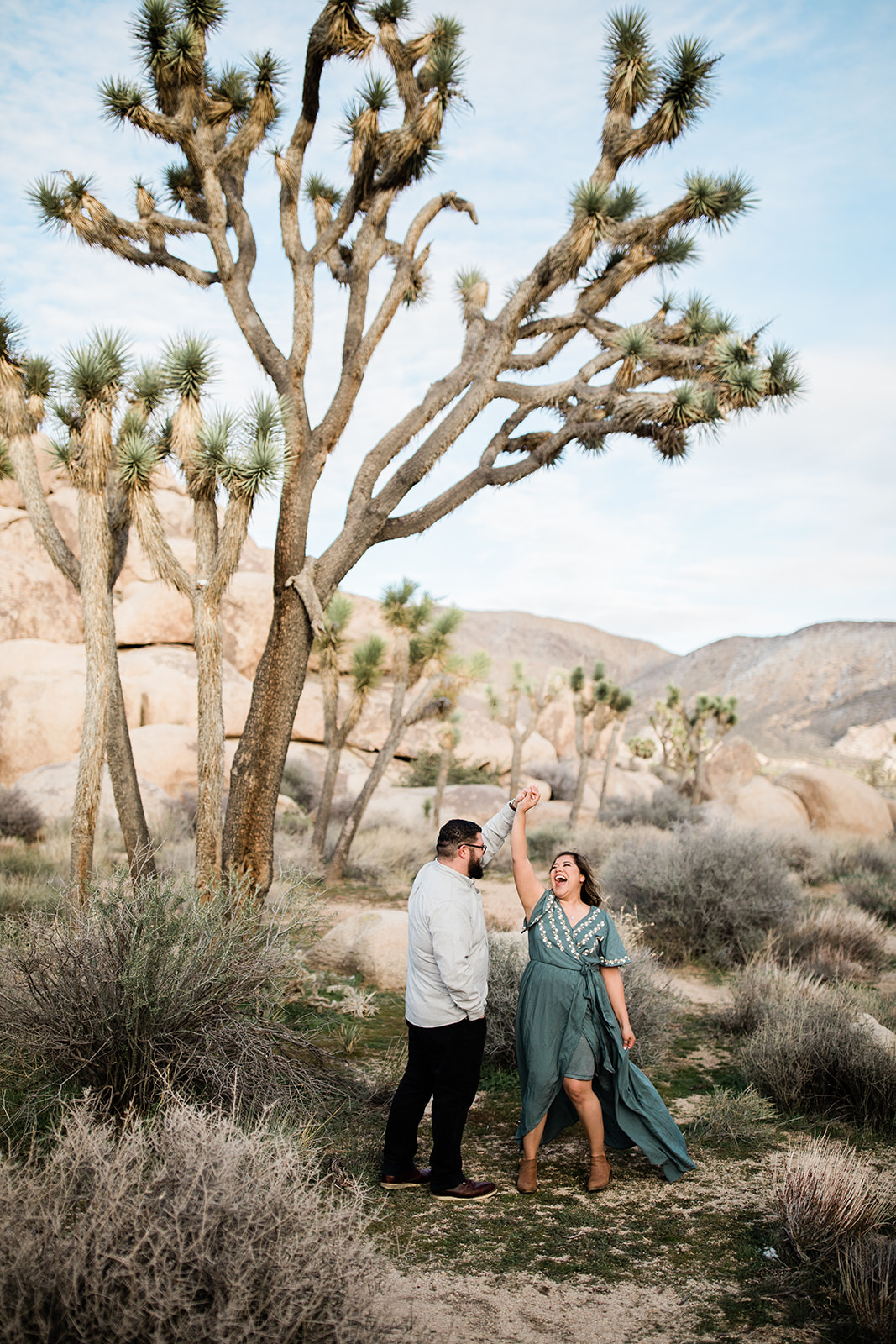 engaged couple dancing under a Joshua Tree