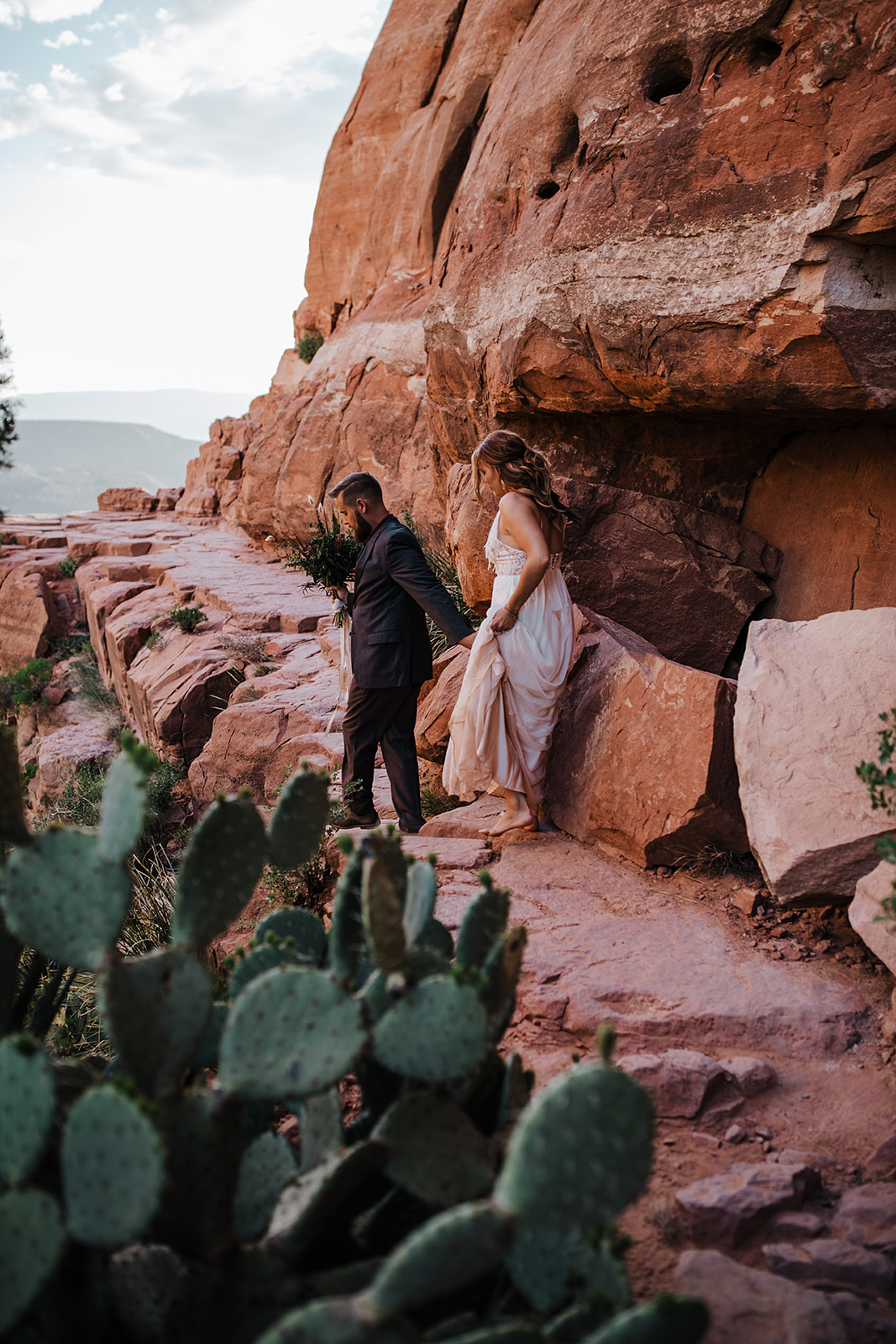 groom leads bride by cactus in the Sedona Arizona desert