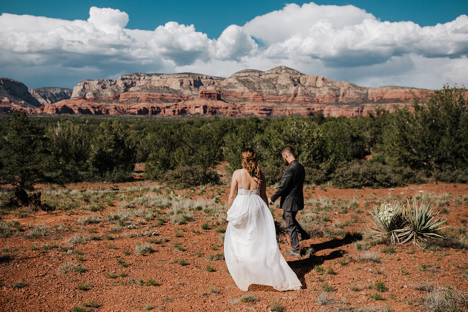 bride and groom walk into Sedona Arizona desert for elopement ceremony