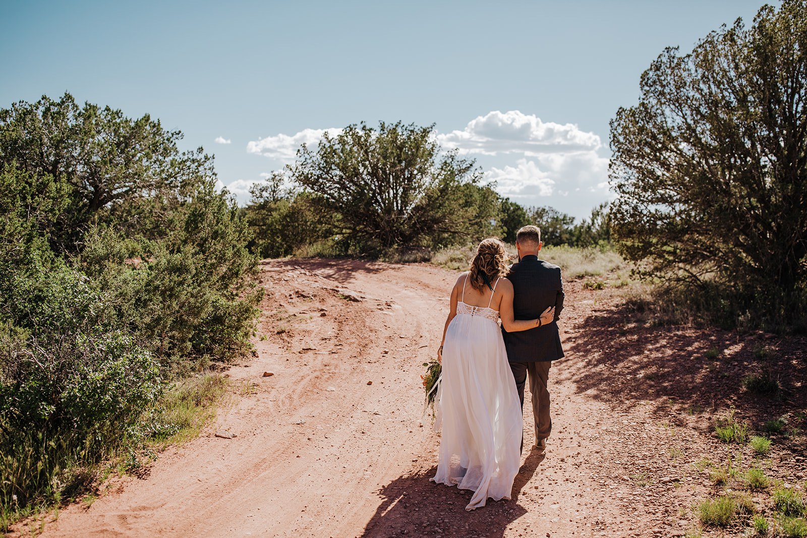 bride and groom walk into Sedona Arizona desert for elopement ceremony