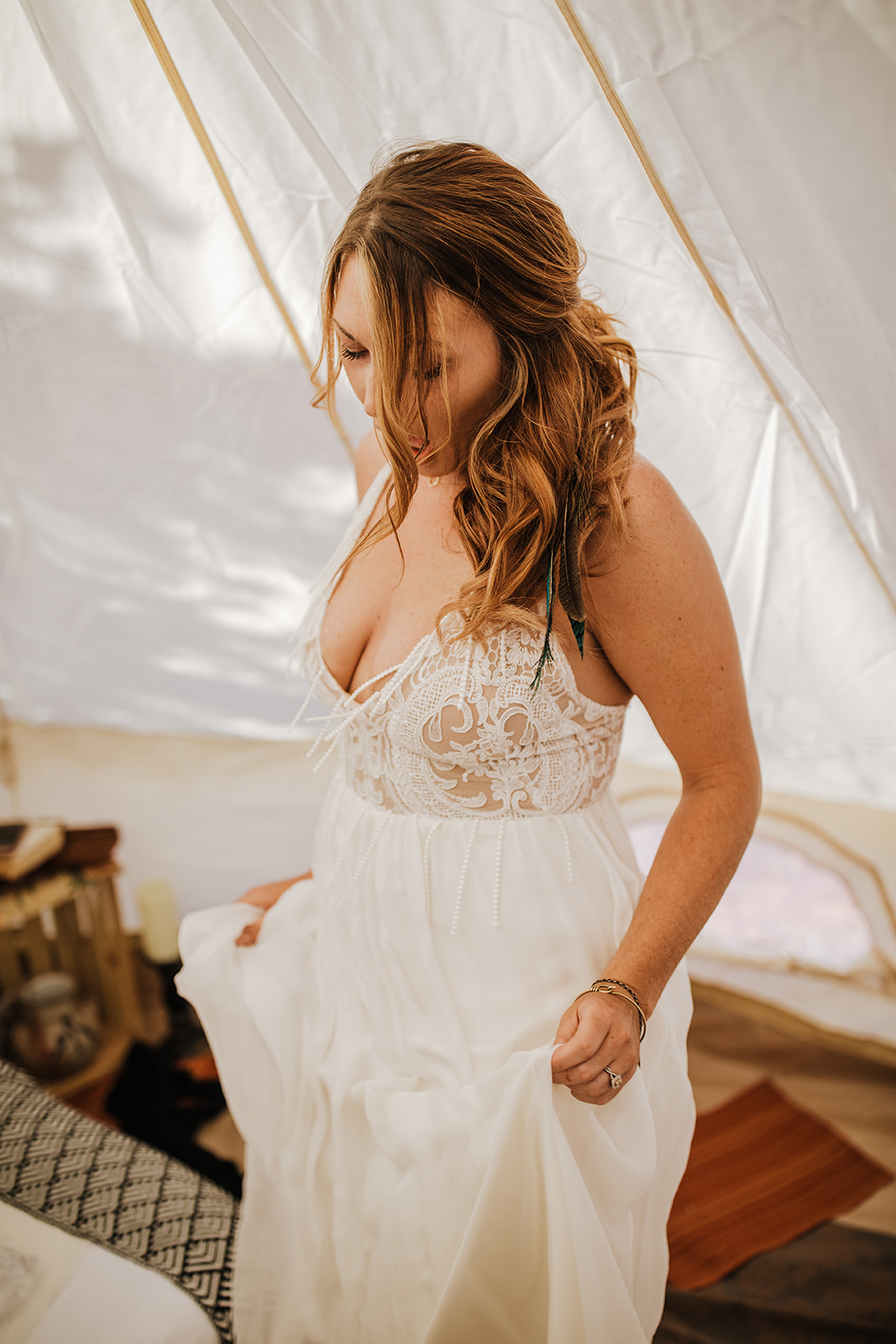 bride getting dressed for desert elopement in desert tent