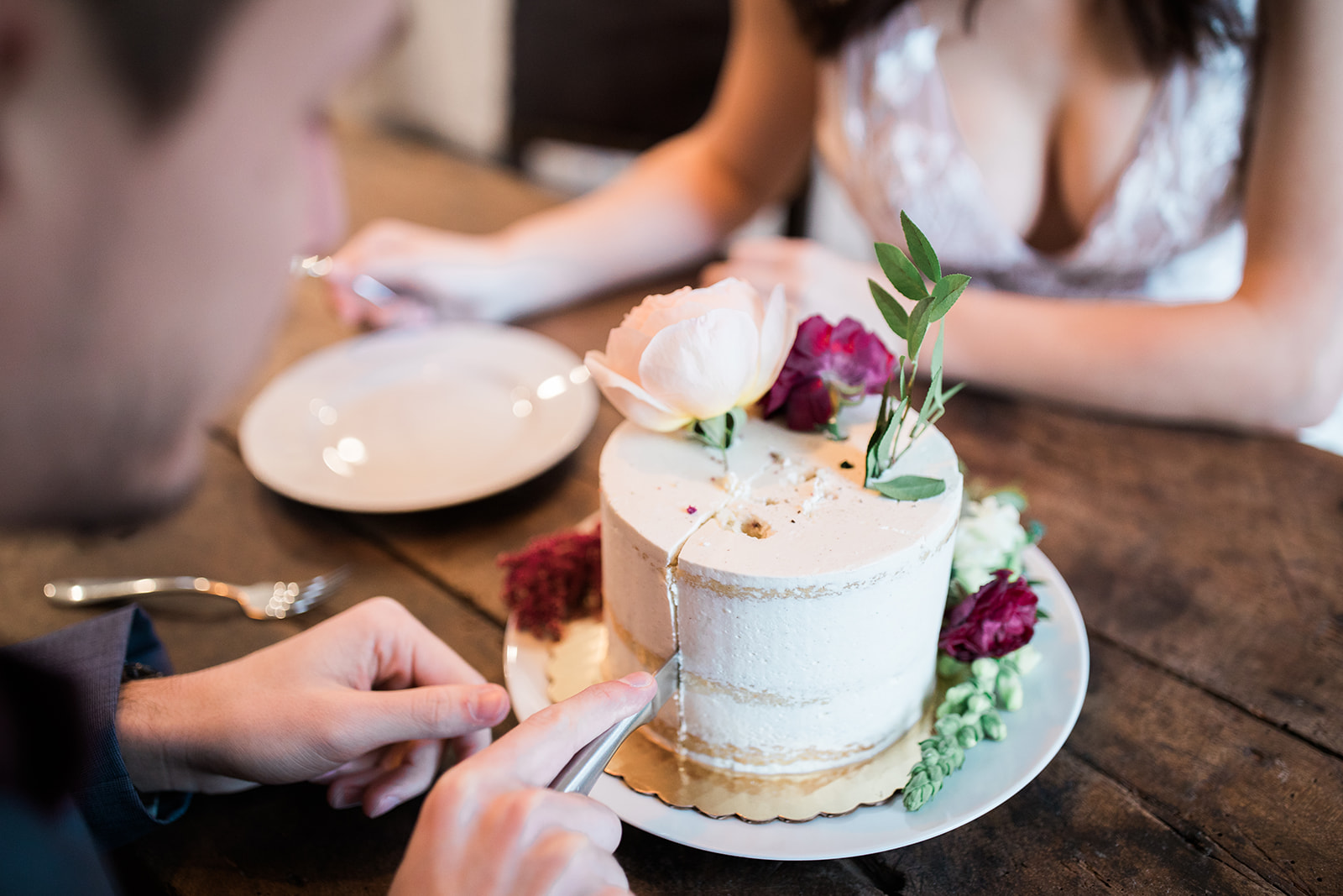 bride and groom cut wedding cake before elopement ceremony