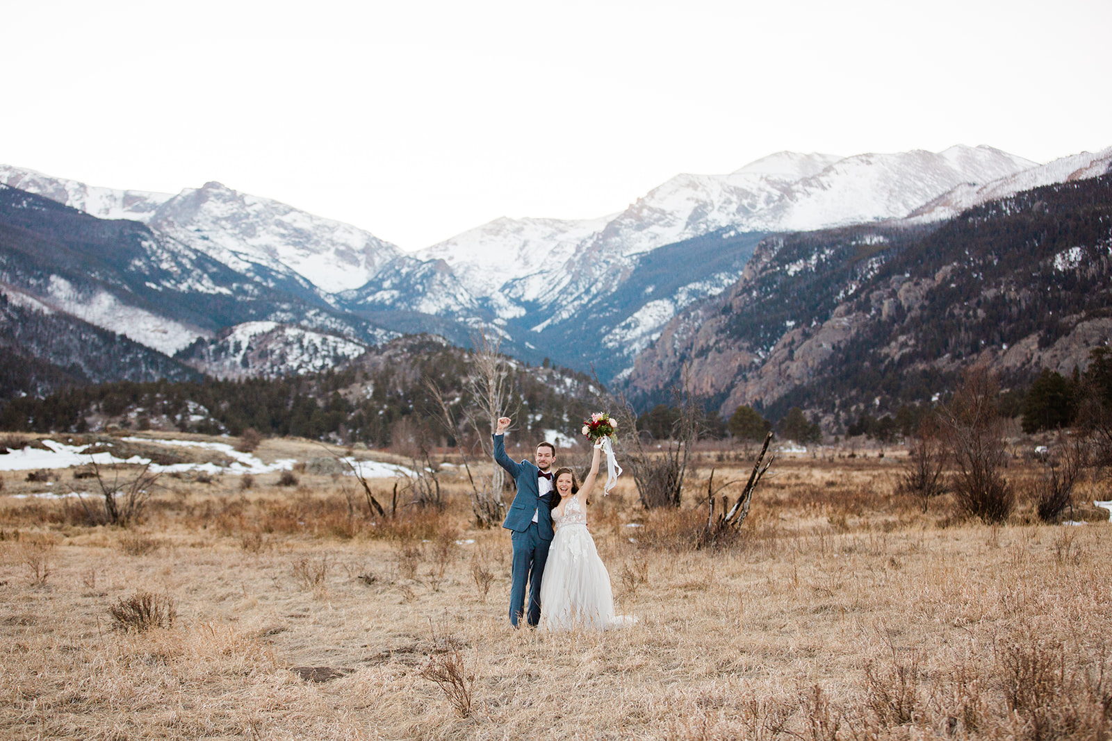 bride and groom kiss in outdoor mountain portrait session in front of Sprague Lake mountain vista