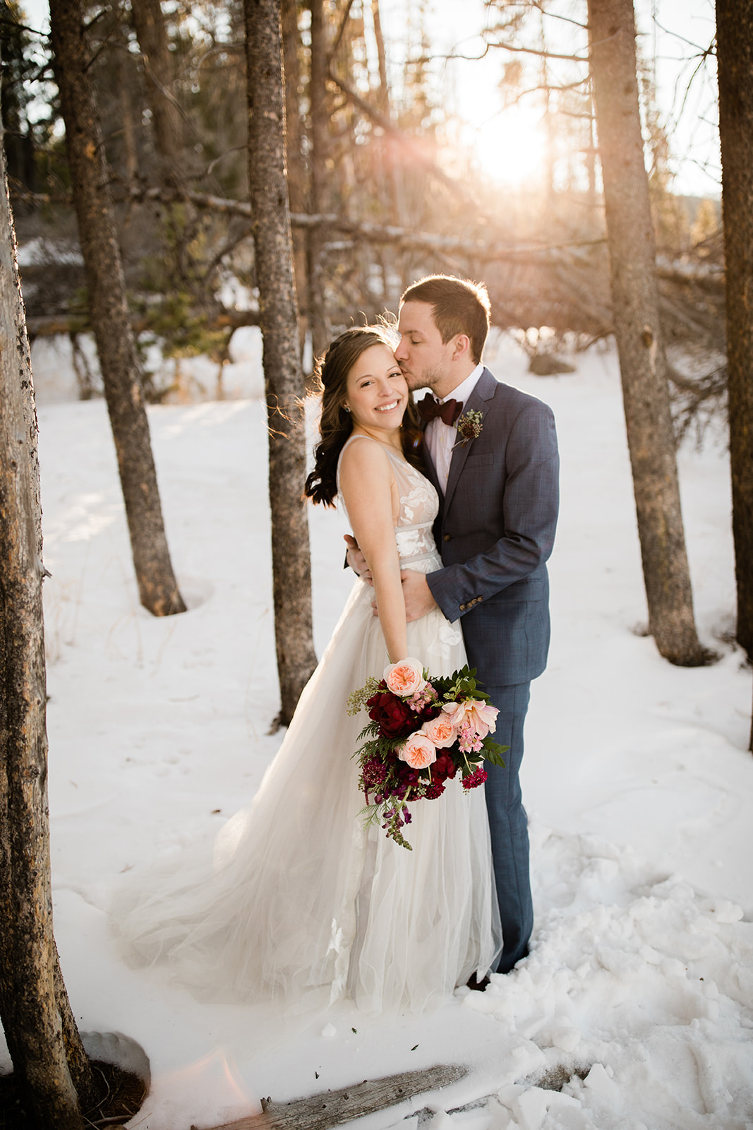 bride and groom in snowy winter woods after Colorado mountain elopement