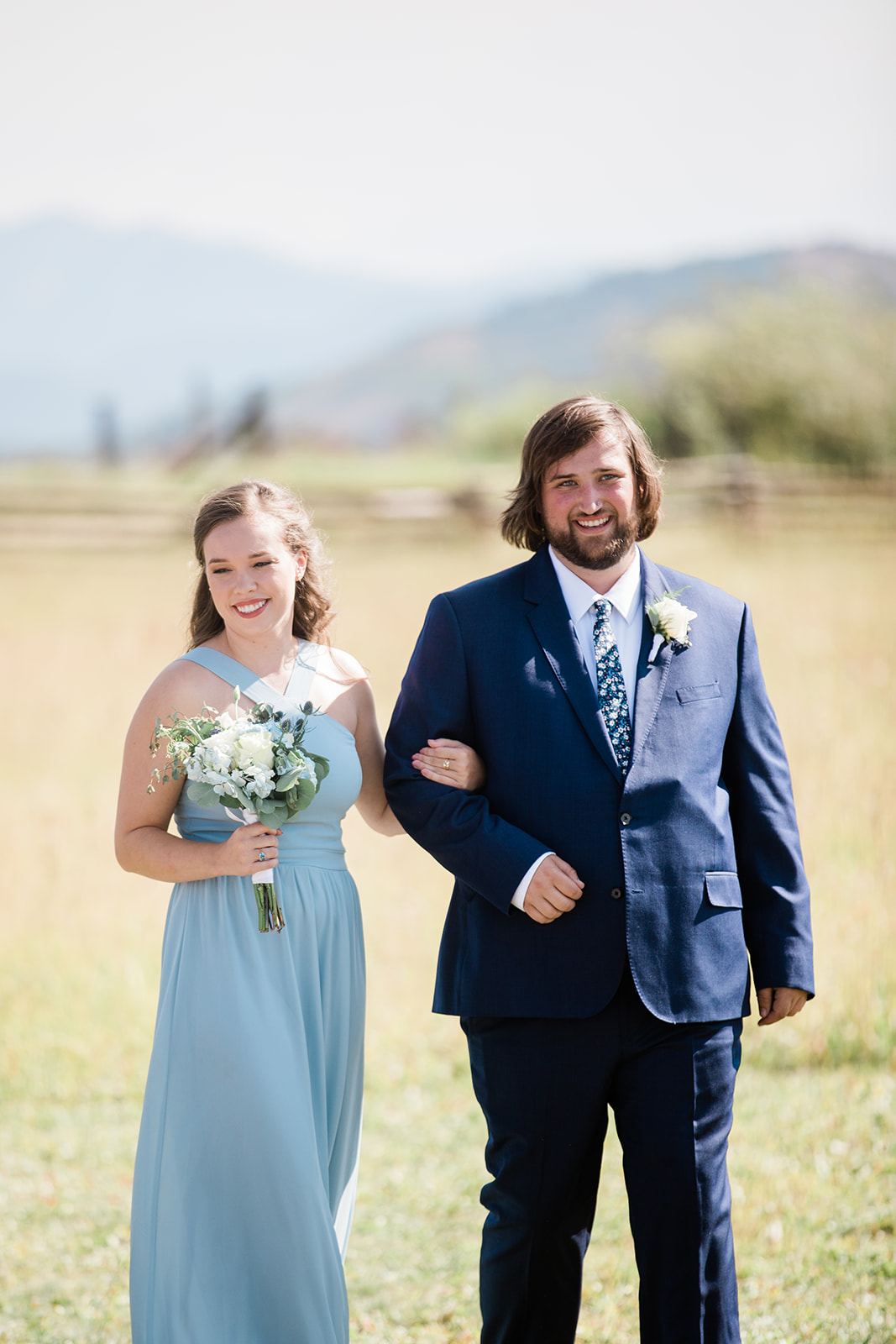 bridal party walks down aisle in outdoor Colorado mountain ranch wedding