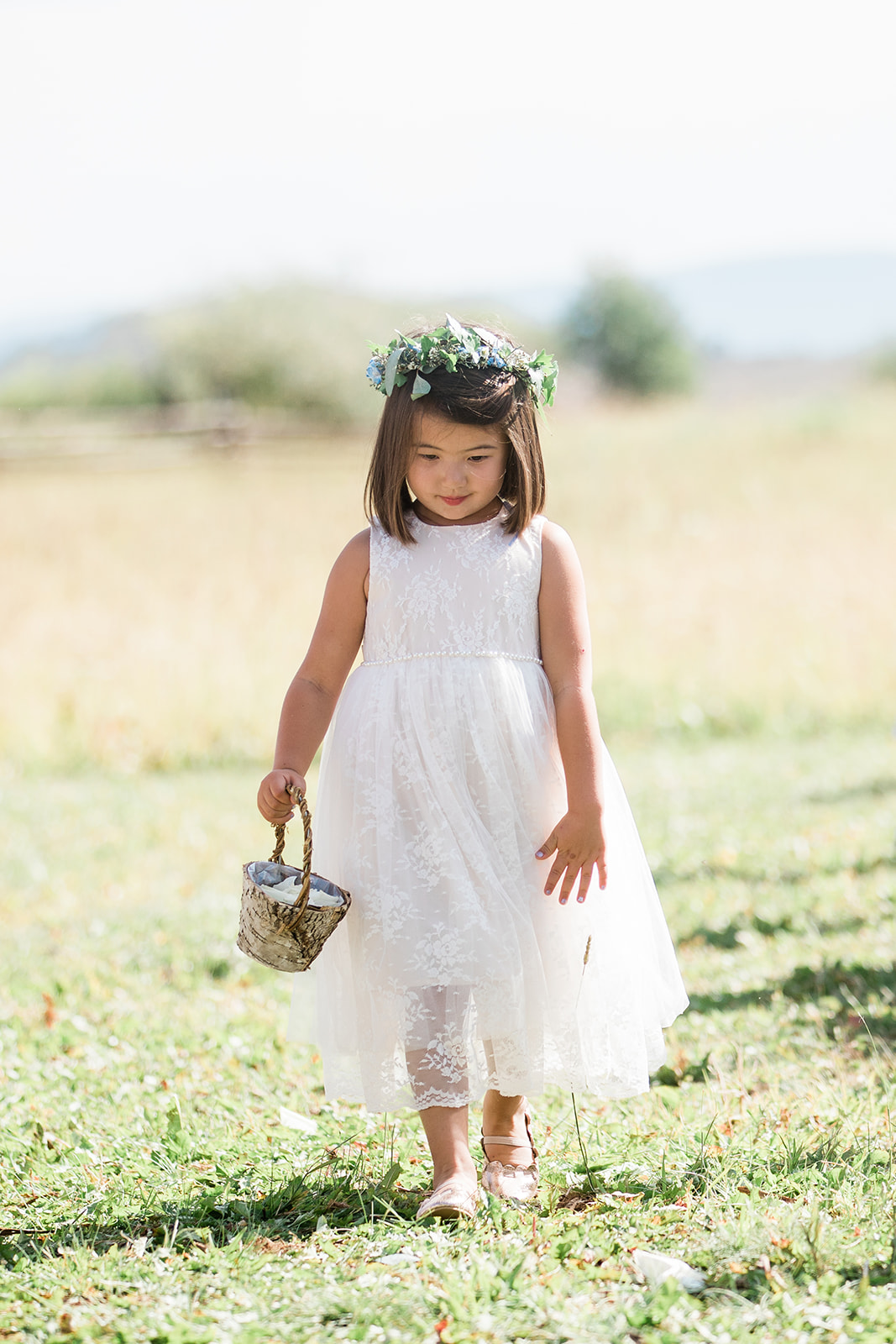 ring bearer and flower girl walks down aisle in outdoor Colorado mountain ranch wedding