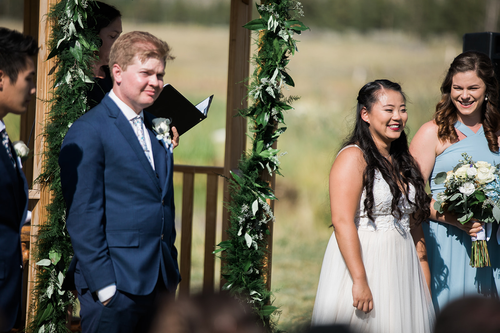 bride and groom look at guests during mountain wedding ceremony