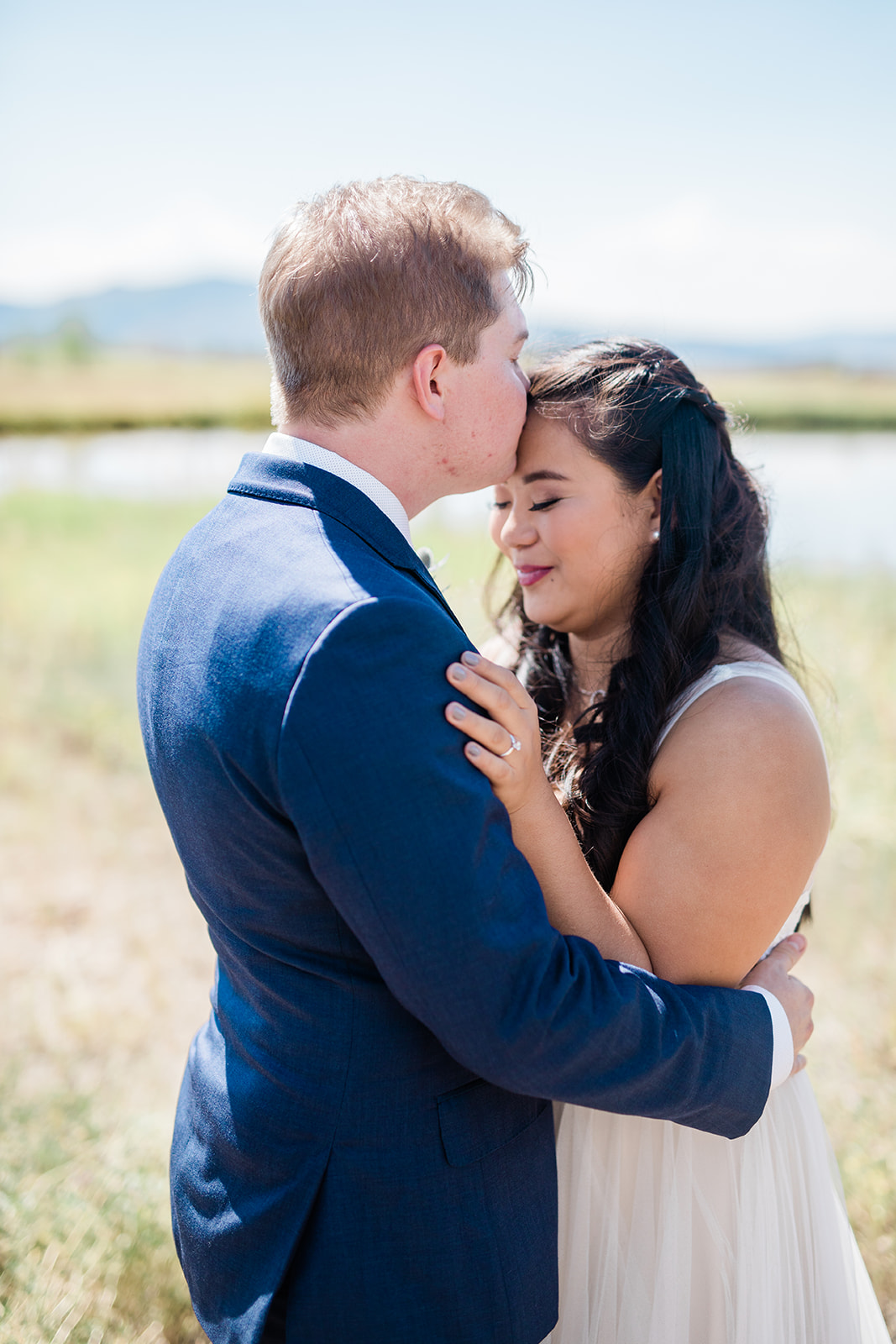 groom kisses bride's forehead in Colorado mountains