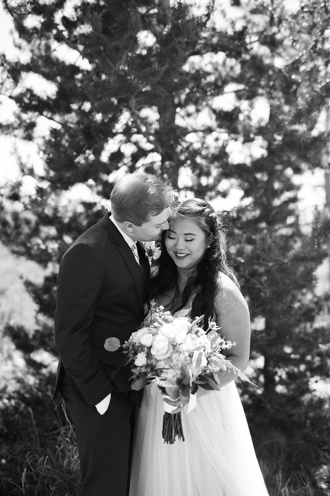 groom snuggles bride before Colorado mountain wedding