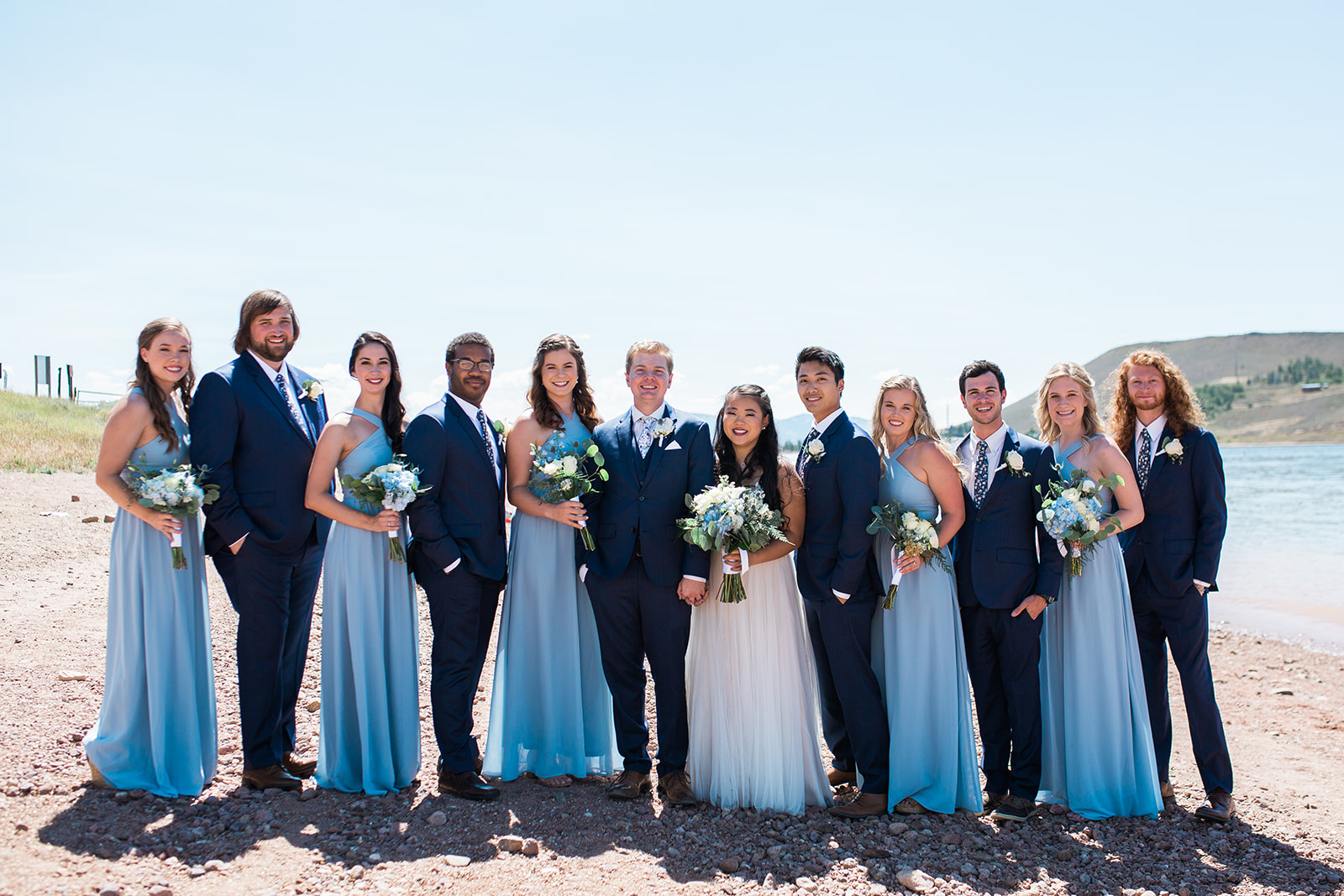 bridal party posing near a Colorado mountain lake
