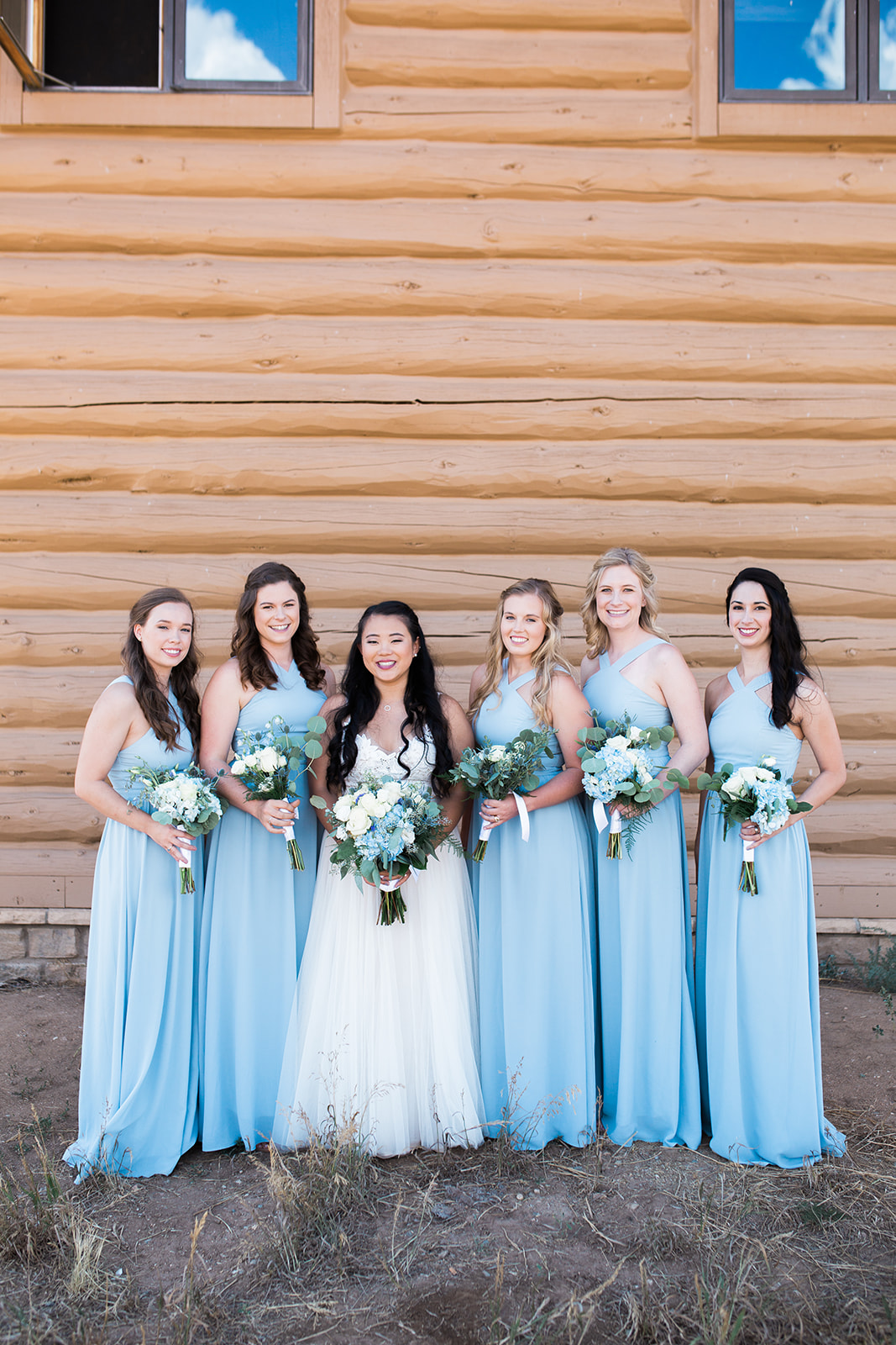 bride and bridesmaids posing outside Crestview Ranch building