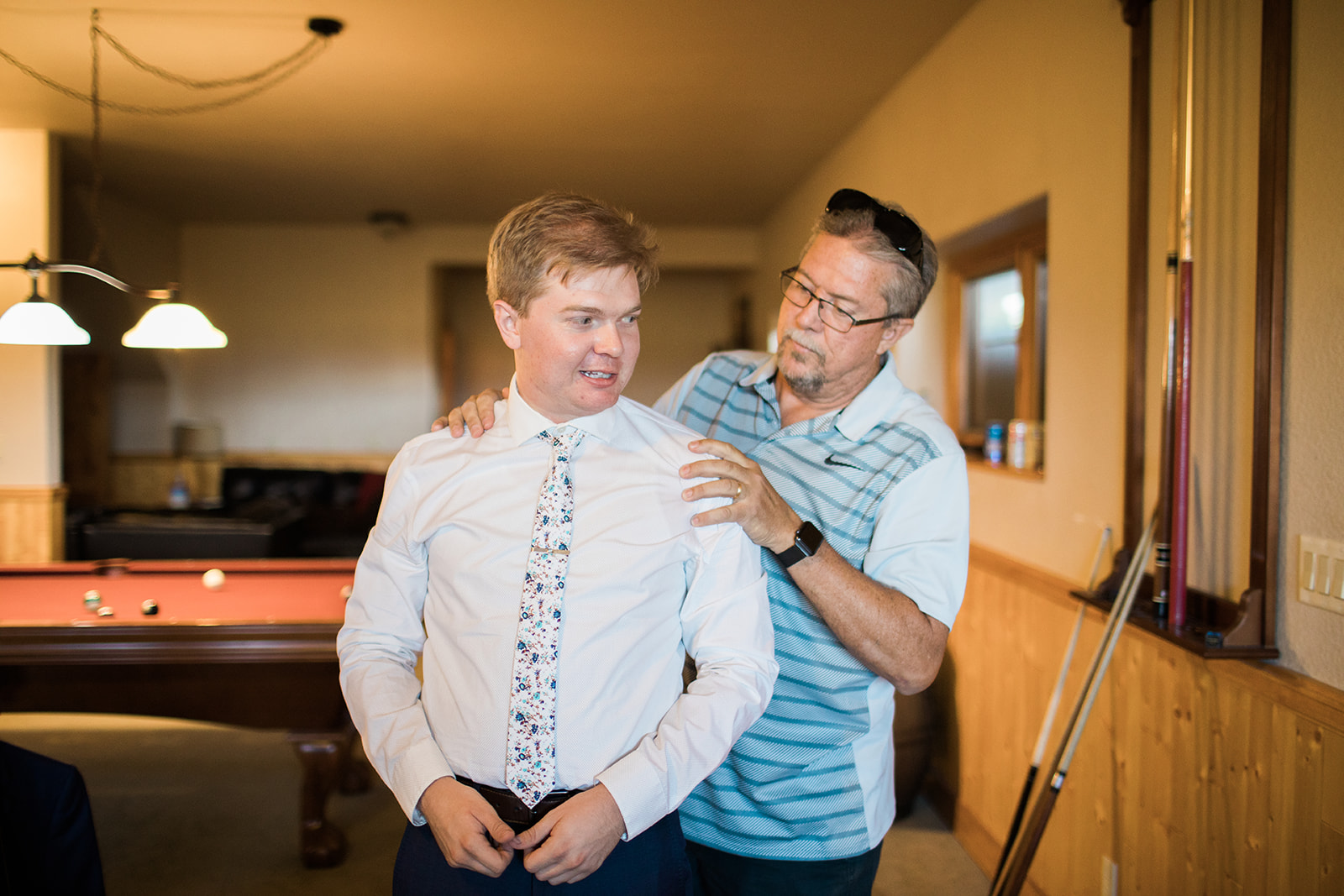 father of the groom helps groom get ready for Crestview Ranch wedding