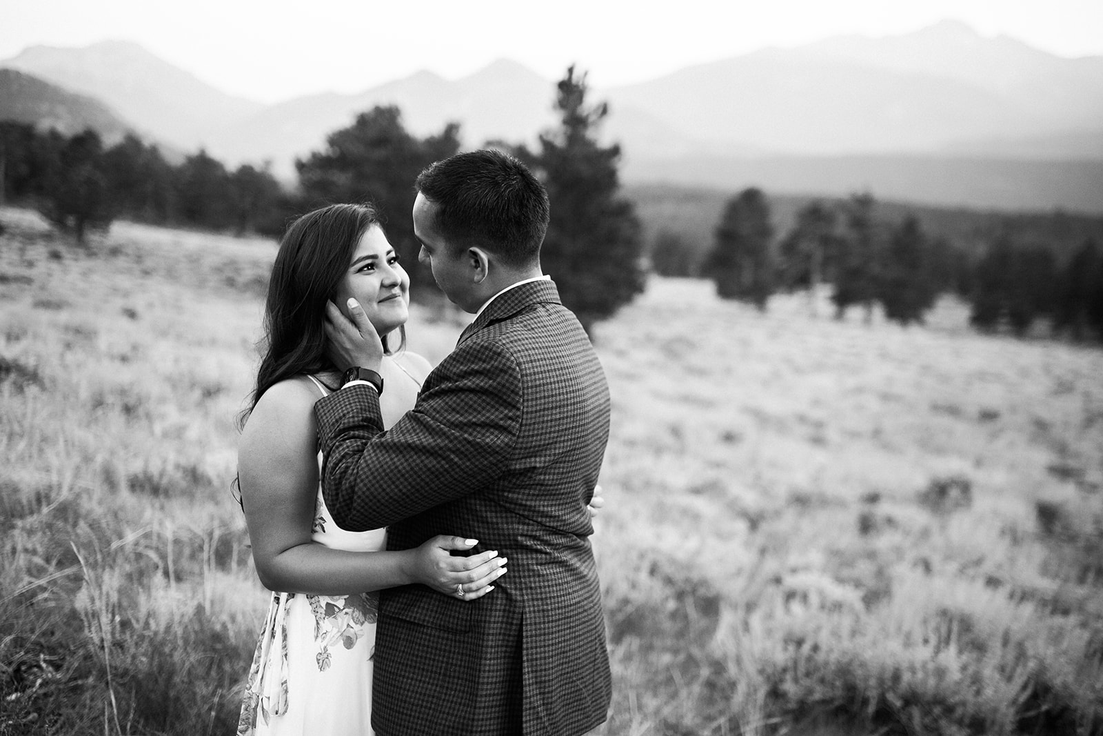 couple walks through RMNP meadow at sunset