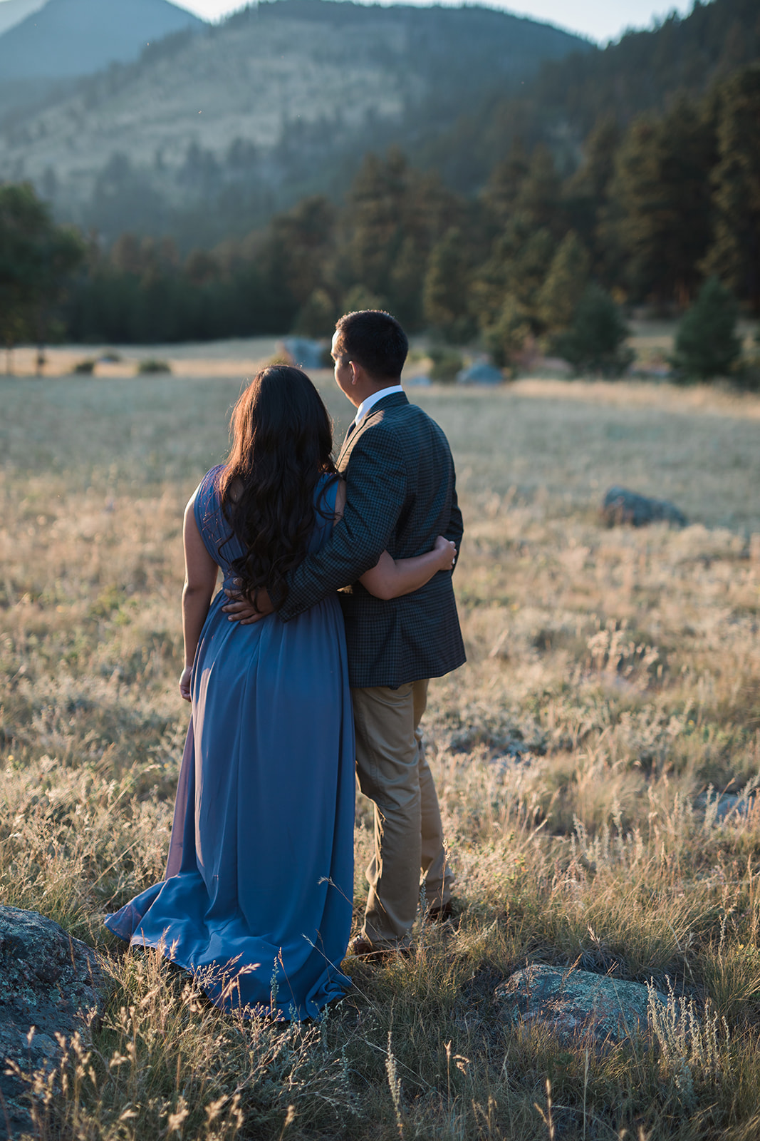 engaged couple looks at sunset in RMNP