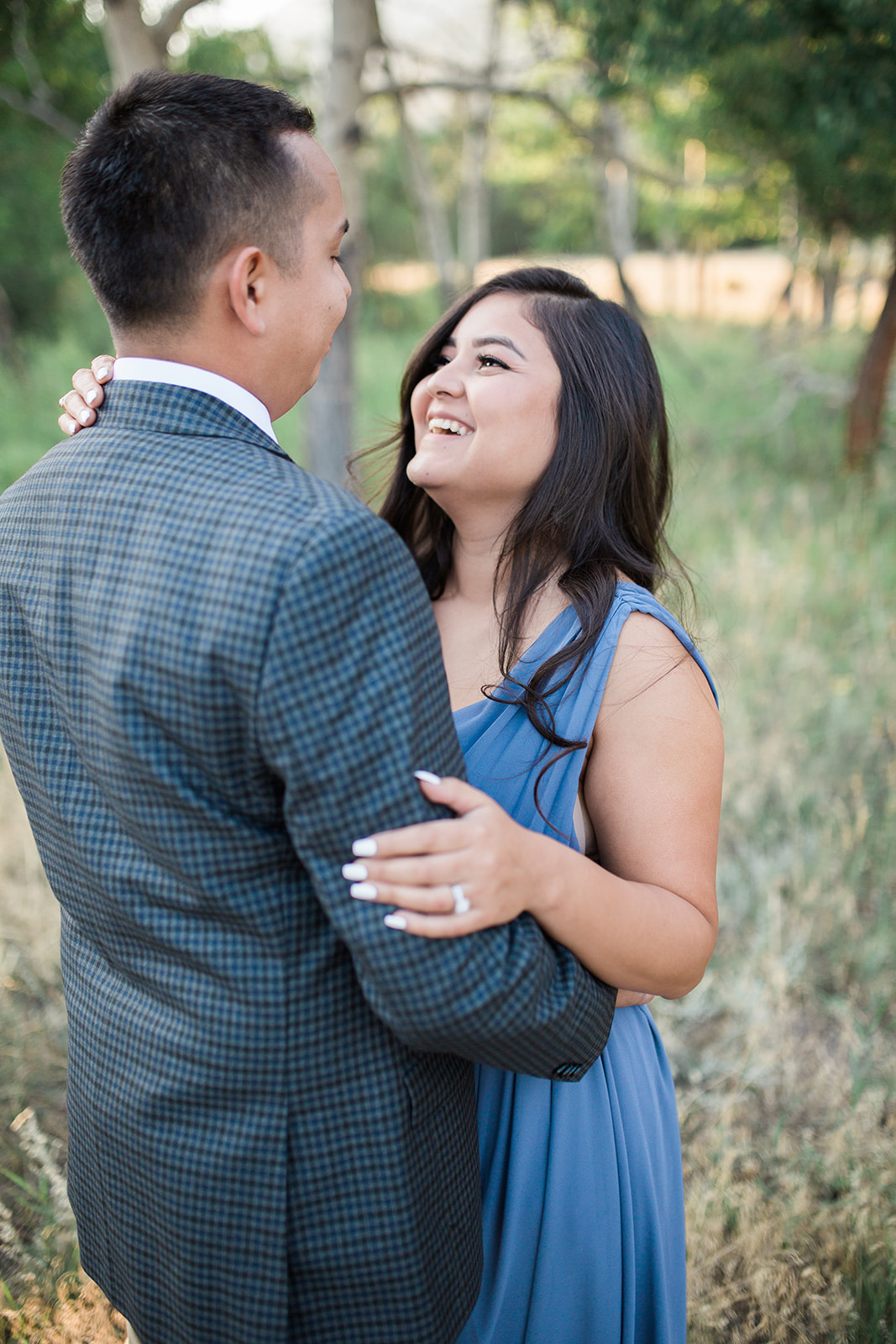 close up engaged couple, plaid jacket blue dress