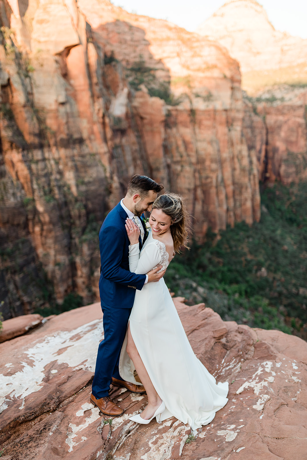 Nick and Kate snuggle in front of a dramatic overlook before their Zion elopement